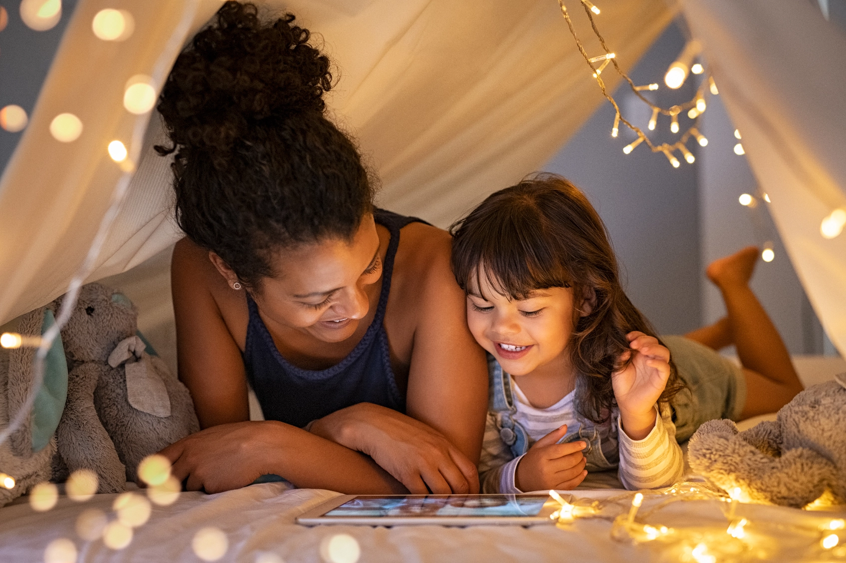 Mother and daughter enjoying content in a play tent